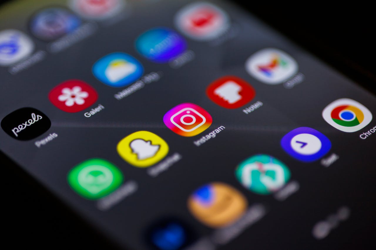programs-01 Close-up view of smartphone home screen featuring popular apps like Instagram, Snapchat, and Chrome.